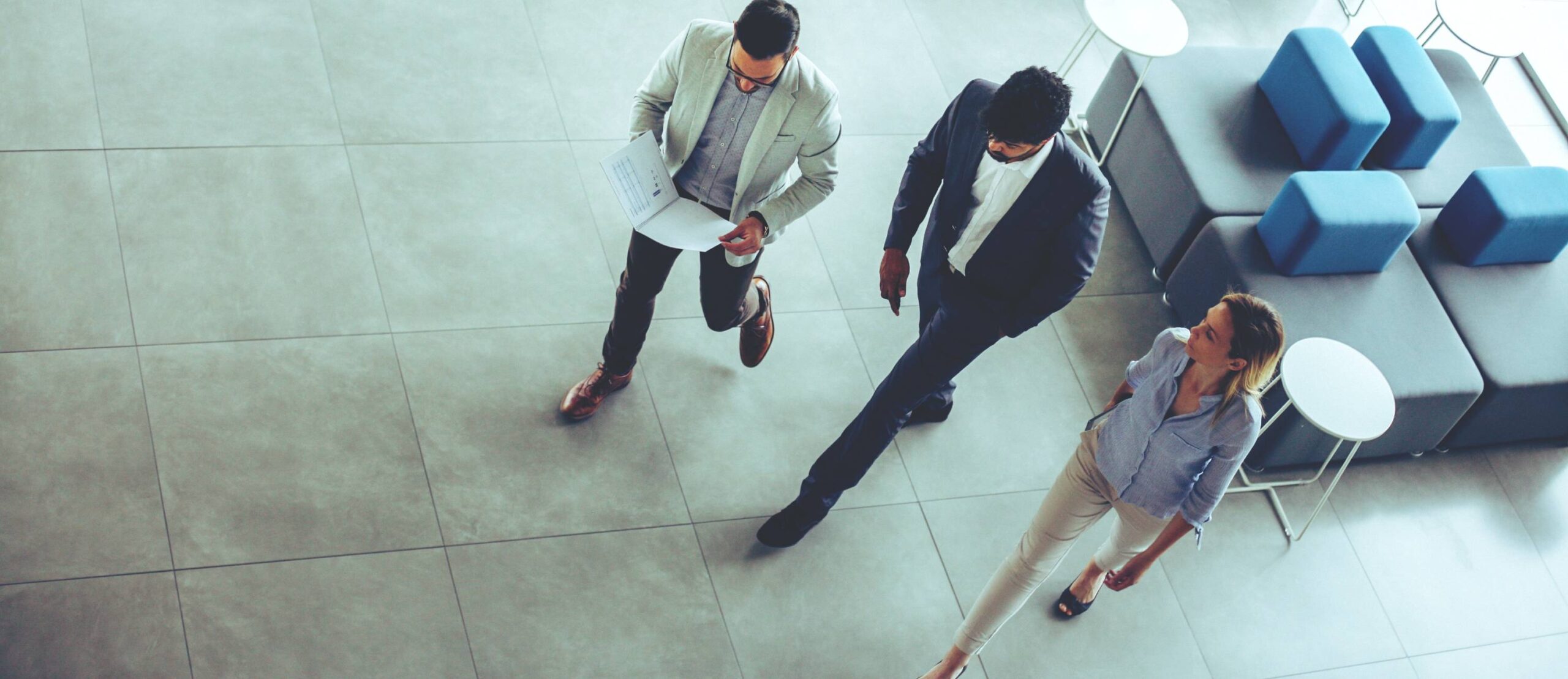 Three people walking together in lobby of building